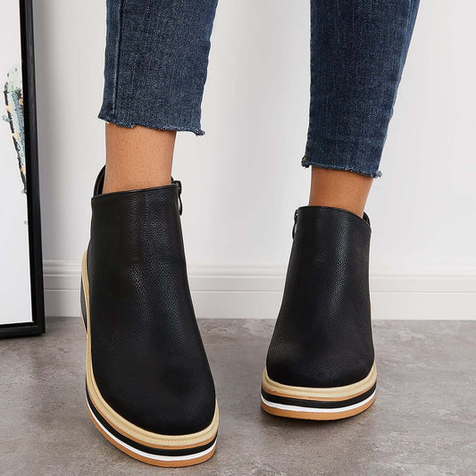 Schwarze Damen-Stiefeletten mit Plateau, kombiniert mit Jeans. Modische, bequeme Schuhe für Herbst und Winter. Ideal für trendbewusste Frauen.