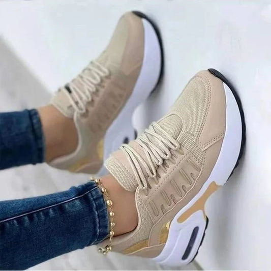 Rote Sneaker mit weißer Sohle und goldenen Akzenten, getragen von Person in blauen Jeans. Modische Sportschuhe, ideal für Freizeit und Sport.