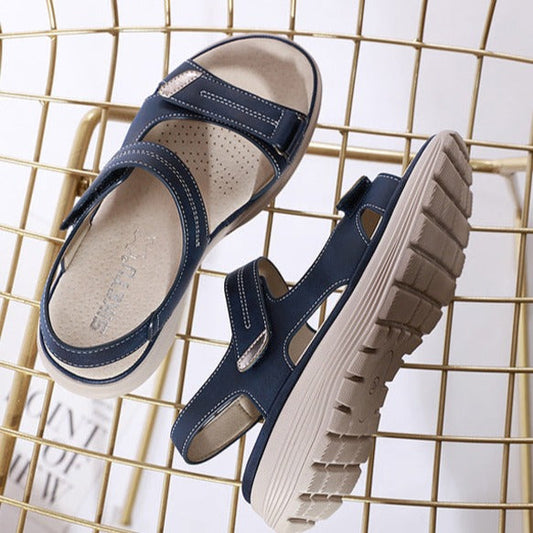Dunkelblaue Sandalen mit Klettverschluss und rutschfester Sohle auf goldenem Gitter. Bequeme Sommerschuhe für Damen. Ideal für Freizeit und Reisen.