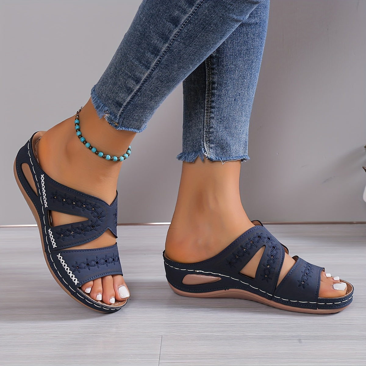 Schwarze Damen-Sandalen mit Keilabsatz, offenem Zehenbereich und dekorativen Ausschnitten, ideal für Sommermode und Freizeitoutfits.